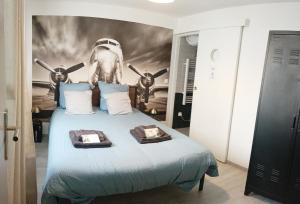 een slaapkamer met een bed met een vliegtuig aan de muur bij La Suite du Pilote in La Ferté-Alais
