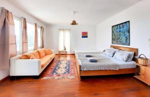 a living room with a bed and a couch at ada-art guesthouse design rooms next to beach in Marmara Adasi