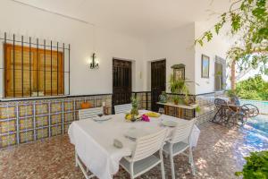 a dining room with a table and chairs and a pool at Villa Maria By Solymar Holiday in Alhaurín de la Torre