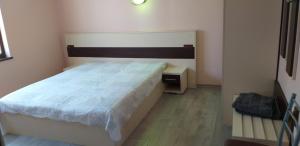 a small bedroom with a bed and a desk at Стаи за нощувки in Sliven