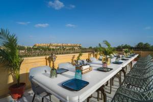 einen langen Tisch mit Stühlen und Vasen auf einem Balkon in der Unterkunft Rupal Residency in Jaisalmer