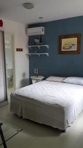 1 dormitorio con 1 cama grande y pared azul en Casa Recanto de Manguinhos, en Búzios
