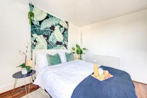 a bedroom with a large white bed with a blue blanket at The London Perfect Attic - sleeps 8 in London