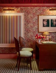 a bathroom with a vanity and a chair and a sink at Broadwick Soho in London