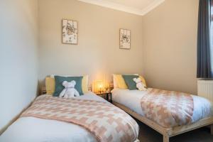 A bed or beds in a room at Stylish 3 Bed House-Free Parking