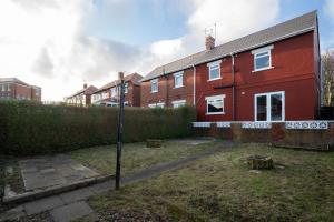 a red brick house with a street light in the yard at Stylish 3 Bed House-Free Parking in Sheriff Hill