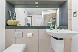 ein Badezimmer mit einem Waschbecken, einem WC und einem Spiegel in der Unterkunft Piccadilly,StJames,Mayfair in heart of London HY17 in London