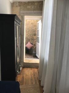 einen Flur mit offener Tür zu einem Zimmer in der Unterkunft The Apartment in Saint-Jean-dʼAngély