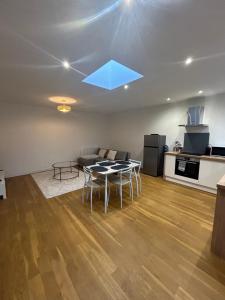 a living room with a table and a kitchen at Le Rive Droite proche gare parking facile in Montauban