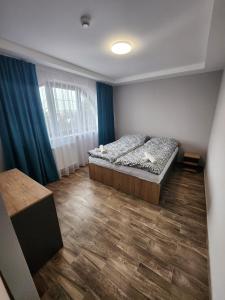 a bedroom with a bed and a wooden floor at Restauracja Biały Kruk in Górno