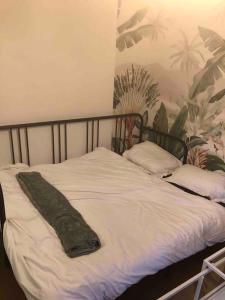 a bed with a green blanket on top of it at Pantin Paris in Pantin