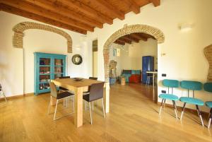 uma sala de jantar com uma mesa de madeira e cadeiras em Welc-ōM Casa a colori nel borgo em Monselice
