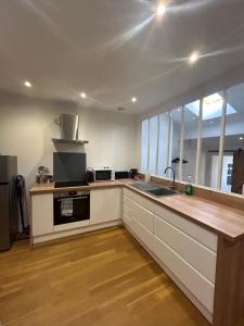 a kitchen with white cabinets and a counter top at Le Rive Droite proche gare parking facile in Montauban +4 photos