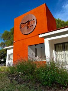 un edificio naranja con un letrero en el costado. en BROTHERS HOSTEl en Villa Allende