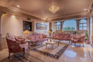 a living room with pink furniture and windows at Rupal Residency in Jaisalmer