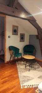 ein Wohnzimmer mit 2 grünen Stühlen und einem Tisch in der Unterkunft Maison de vacances in Bias