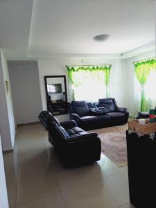 una sala de estar con 2 sofás negros en Lot 15168 Zeerust Road, en Tlokweng