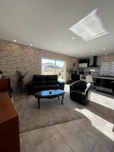 ein Wohnzimmer mit einem Sofa und einem Couchtisch in der Unterkunft Maison avec piscine entièrement climatisée in Sauvian