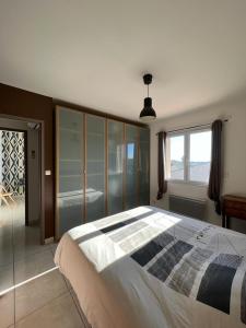 ein Schlafzimmer mit einem großen Bett und einem Fenster in der Unterkunft Maison avec piscine entièrement climatisée in Sauvian