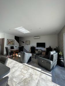 ein Wohnzimmer mit einem Sofa und einem Tisch in der Unterkunft Maison avec piscine entièrement climatisée in Sauvian