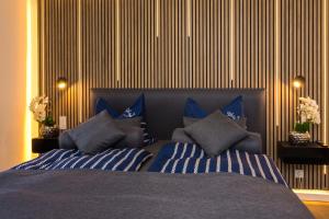 a bedroom with a bed with blue and white pillows at Villa Marin Wohnung 1 in Zinnowitz +8 photos