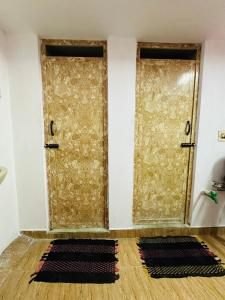 two doors in a room with two mats on the floor at Amaravathi Home Stay in Tiruvannāmalai