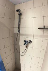 a shower with a hose on a tiled wall at Katariina House in Pärnu