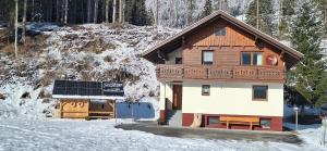 ein Haus mit Sonnenkollektor im Schnee in der Unterkunft Chalet Lärchforst in Aich