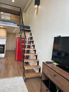 a staircase leading to a living room with a television at Stylish&Cozy Loft Žuvėdra near City Center in Vilnius