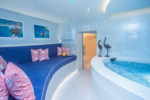 a room with a tub with a bed and a swimming pool at Harbour Hotel & Spa Chichester in Chichester