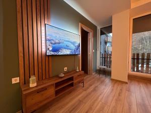 Adora's Apartment Mavrovo في مافروفو: غرفة معيشة مع تلفزيون بشاشة مسطحة على جدار