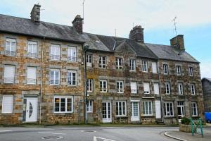 an old brick building with white windows on a street at The Bay - Maison au calme à 20min de la plage in La Haye-Pesnel