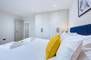 um quarto branco com armários brancos e uma cama em Hybrid Resi - Uxbridge em Uxbridge
