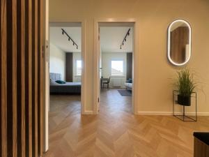 a hallway with a living room and a mirror at Stylish 3 bedroom apartment with balcony in Płock