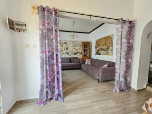 a living room with purple curtains and a couch at Dreamer's Home Chrisa in Limenas