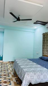1 dormitorio con 1 cama y ventilador de techo en R R Villa, en Alibaug