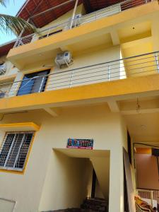 un edificio con un balcón con un cartel. en R R Villa, en Alibaug