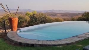 a swimming pool with a vase sitting next to it at Opuwo Country Lodge Campsite in Opuwo