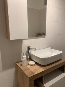 bagno con lavandino bianco e specchio di La casa di Tina - Civenna a Civenna