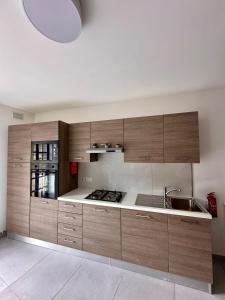 a kitchen with wooden cabinets and a sink at Mosta Dome Penthouse in Mosta +37 photos