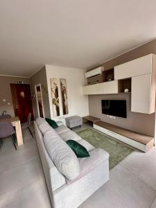 a living room with a white couch and a television at Mosta Dome Penthouse in Mosta