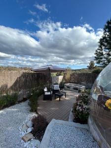eine Terrasse mit einem Tisch, einem Sonnenschirm und einem Auto in der Unterkunft Sky Dreams Experience Suite Garnacha in Avila