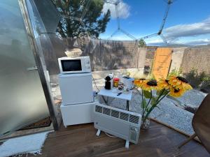 eine Küche mit einem Kühlschrank und einem Tisch mit einer Mikrowelle in der Unterkunft Sky Dreams Experience Suite Garnacha in Avila