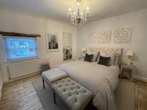 Un dormitorio con una cama grande y una lámpara de araña. en 3-storey luxury Georgian house, High St, Henley-in-Arden, en Henley-in-Arden