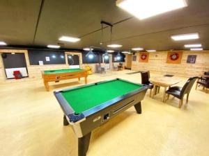 a billiard room with a pool table and tables at Griffon Lodge in Morpeth