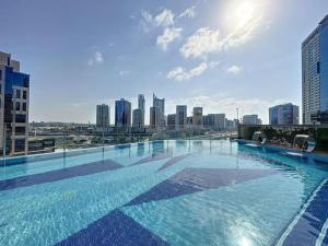 uma grande piscina com um horizonte da cidade ao fundo em White Sage - Elite Residence 1 bedroom em Dubai
