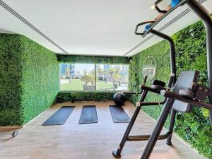 um ginásio interior com uma parede verde em White Sage - Elite Residence 1 bedroom em Dubai