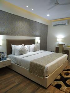 a bedroom with a large bed with white pillows at Le Tokyo Hotel Vithalapur in Vithalpur