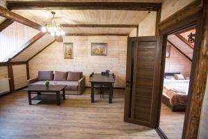 Готель Бережани في Brzezhany: غرفة معيشة مع أريكة وطاولة