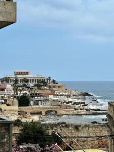a view of a beach with buildings and the ocean at Bookarest Hostel Malta in St. Julianʼs